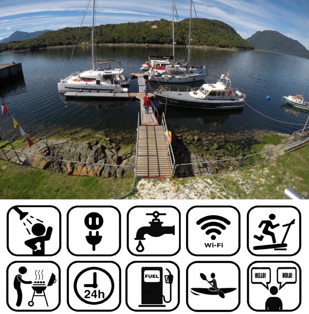 a wooden dock leading down to the water with several boats moored to it either side