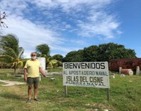 brian simm in front of the welcome sign at swan islands