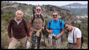 a group of men on an arid hillside with backpacks and sunglasses out for a trek