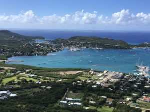 taken from a high peak looking down over 2 harbors with bright blue water that almost join except for a narrow strip of land