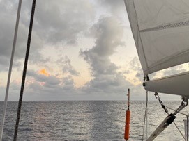 pale dawn sky with smoky rising clouds and a flat sea